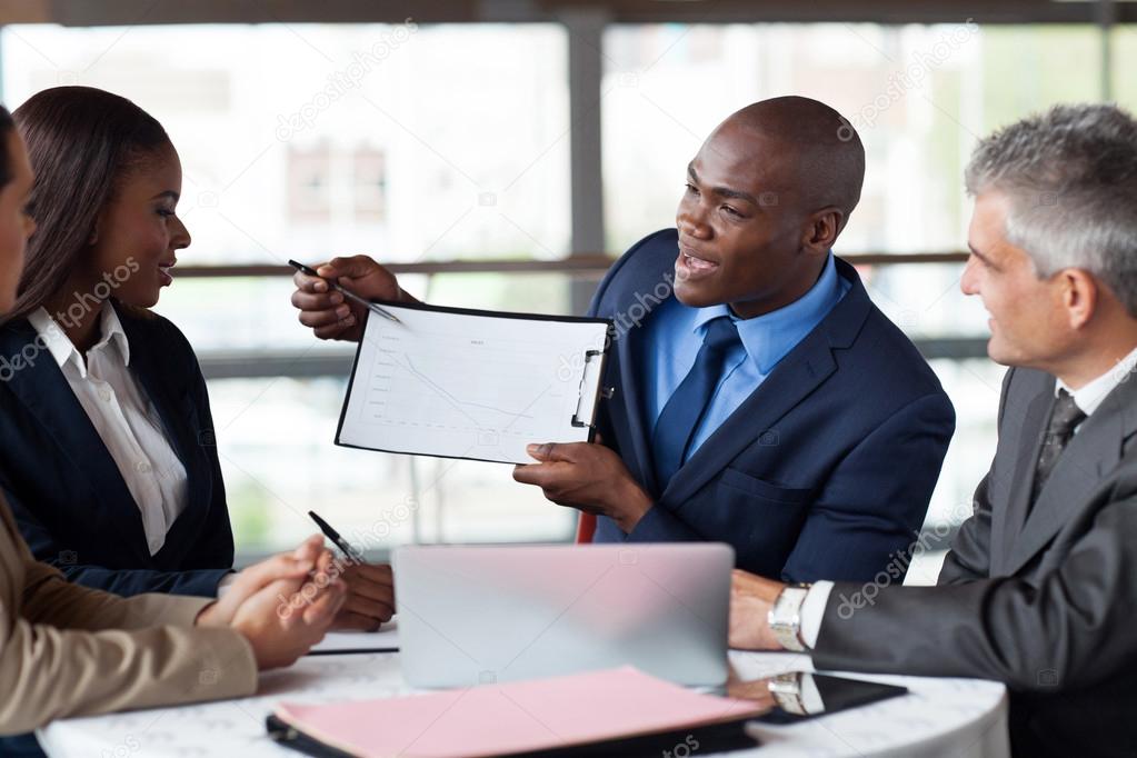 Young african american businessman presenting figures at a meeti