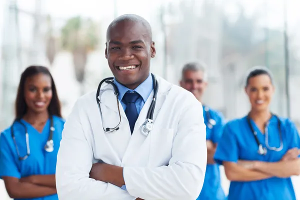 Medico afroamericano con colleghi sullo sfondo — Foto Stock