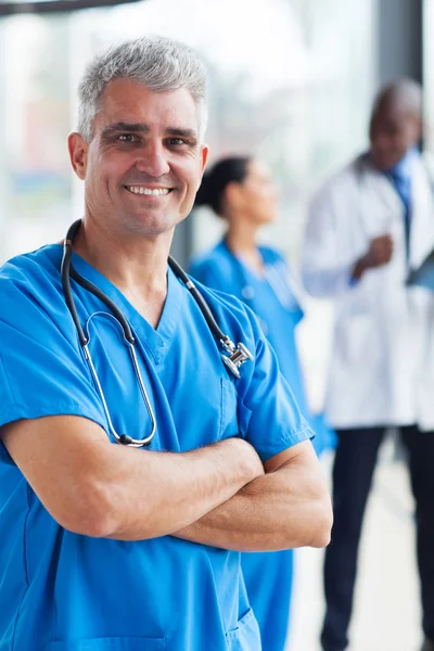 Médico de mediana edad con los brazos cruzados —  Fotos de Stock