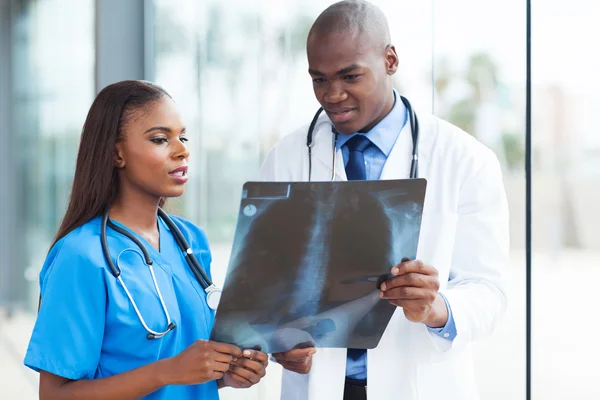 Afrikaanse Amerikaanse medische arbeiders bestuderen van patiënt x-ray — Stockfoto