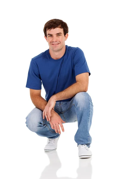 Casual man squatting on white Stock Photo