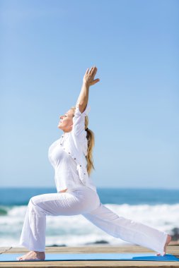 kadın kıdemli yoga egzersiz kumsalda
