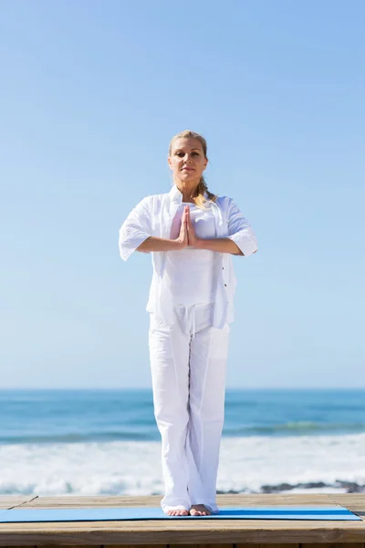 Senior woman yoga on beach — Stock Photo, Image