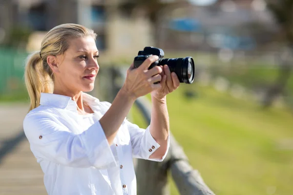 Mulher de meia idade tirando fotos ao ar livre — Fotografia de Stock