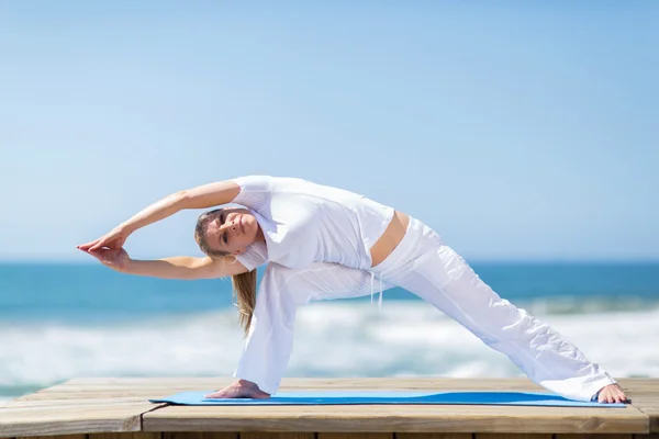 Подходит женщина средних лет, делающая упражнения на пляже — стоковое фото