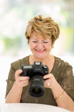 emekli kadın fotoğraf makinesinde fotoğrafların görüntülenmesi