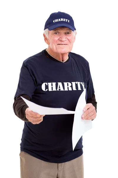 Senior charity worker handing out papers — Stock Photo, Image