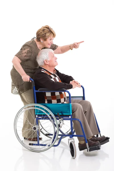 Äldre kvinnan bakom funktionshindrade make och pekar — Stockfoto