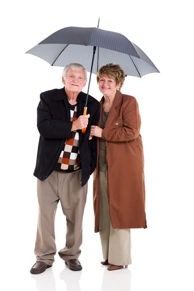 Casal aposentado sob um guarda-chuva — Fotografia de Stock