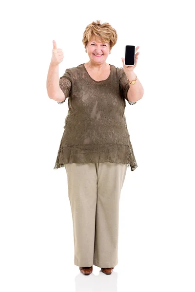 Пожилая женщина держит смартфон и делает большой палец вверх — стоковое фото