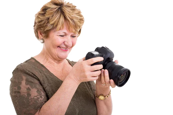 Retired woman viewing photos on digital SLR camera — Stock Photo, Image