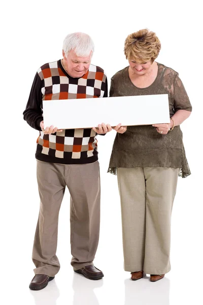 Retired couple holding white banner — Stock Photo, Image