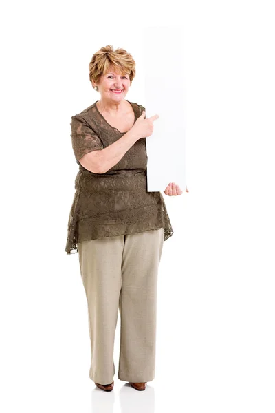 Elderly woman pointing at empty white board — Stock Photo, Image