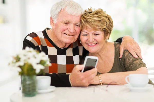 Casal de idosos usando telefone inteligente — Fotografia de Stock