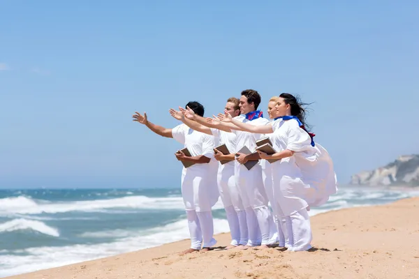 Joven coro de iglesia cantando en la playa — Foto de Stock