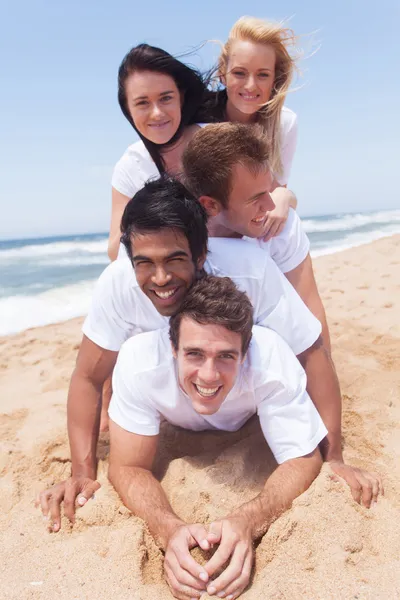 Grupo de amigos deitado pirâmide na praia — Fotografia de Stock