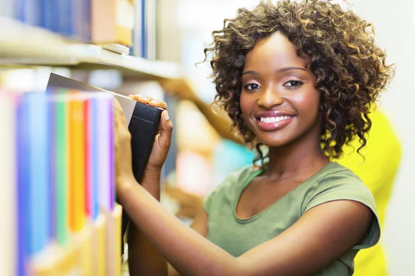 Chica rizada buscando libro — Foto de Stock