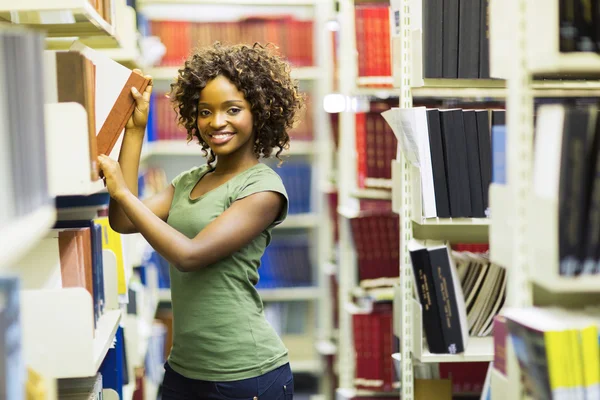 Curly estudante universitário na biblioteca — Fotografia de Stock