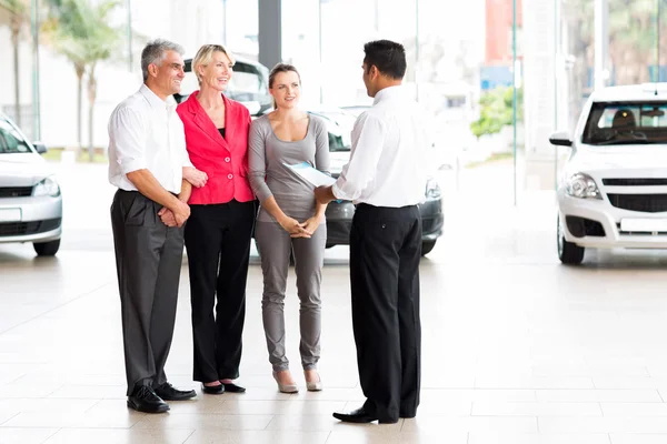 Vehicle salesman explaining contract to family — Stock Photo, Image