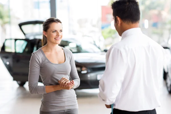Vendedor de carros conversando com a jovem — Fotografia de Stock