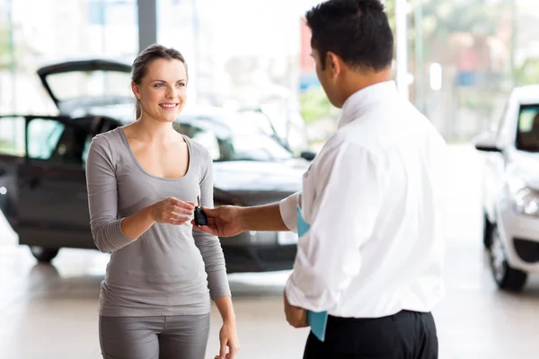 Jeune femme recevant sa clé de voiture — Photo