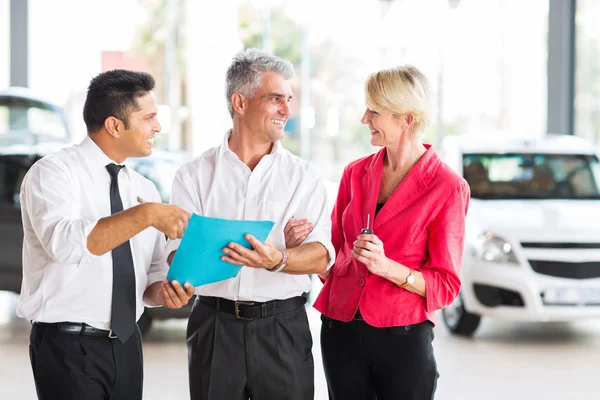 Man talking to wife in dealership — Stock Photo, Image