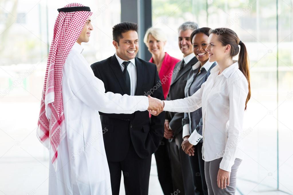 Businesspeople welcoming Islamic businessman