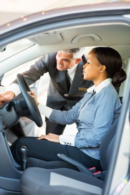 bir arabayı gösterilen üst düzey satış elemanı