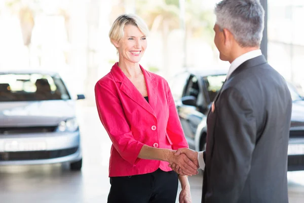 Metoda handshaking zralá žena s prodejci aut — Stock fotografie