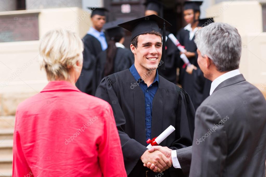 Male graduate handshaking with his father