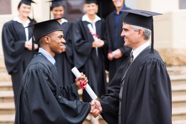 Smiling graduate handshaking with dean clipart