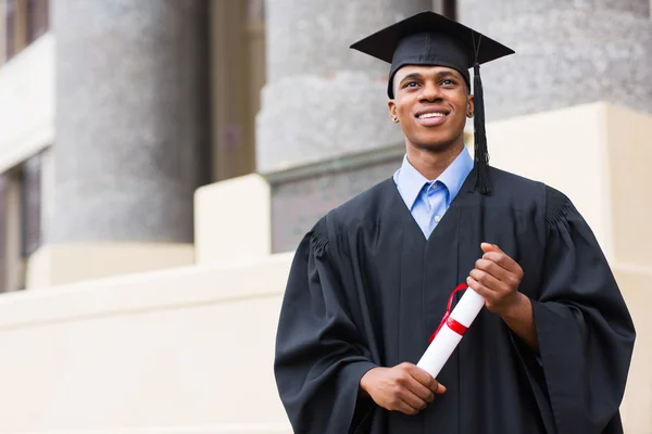 Graduate standing in front of university — Stock Photo, Image