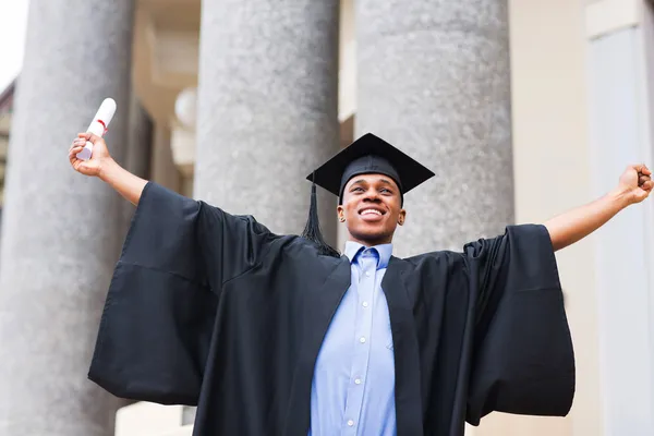 Graduado com braços estendidos segurando seu diploma — Fotografia de Stock