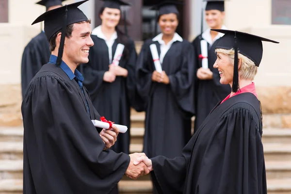 Graduado estrechando la mano con el profesor — Foto de Stock