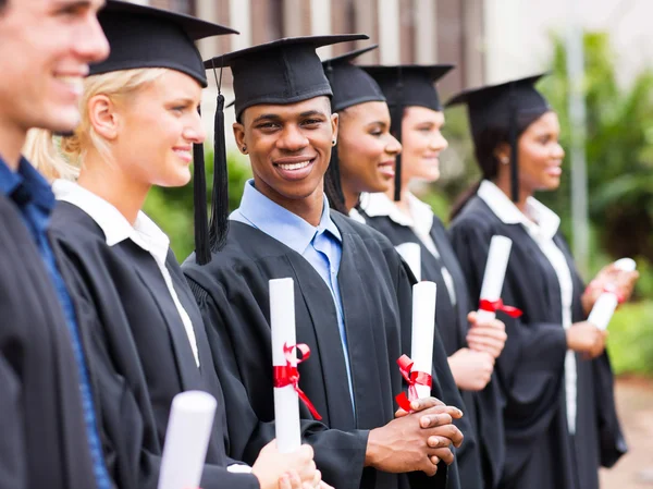 Multiracial graduation standing in a row — Stock Photo, Image