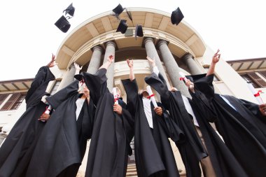 Graduates throwing graduation hats