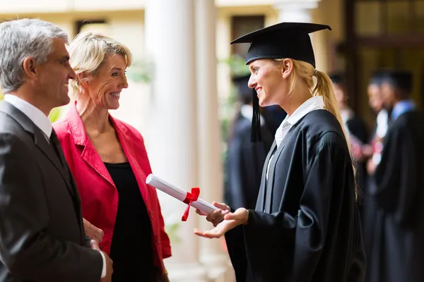 Female graduate talking to parents — Stock Photo, Image