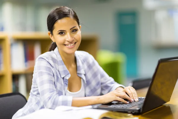 Estudante usando laptop na biblioteca — Fotografia de Stock