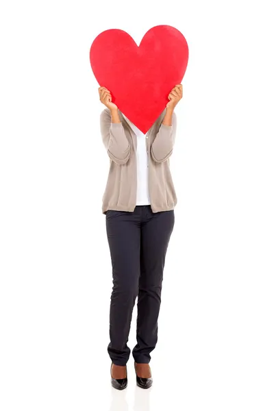 Young woman hiding her face behind heart shape — Stock Photo, Image