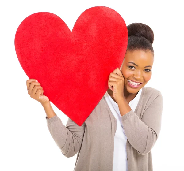 Heureuse femme africaine tenant le symbole du cœur rouge — Photo