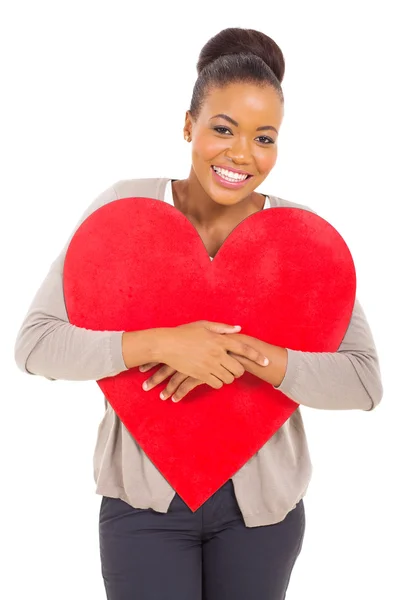 Mujer africana joven abrazando forma de corazón rojo — Foto de Stock