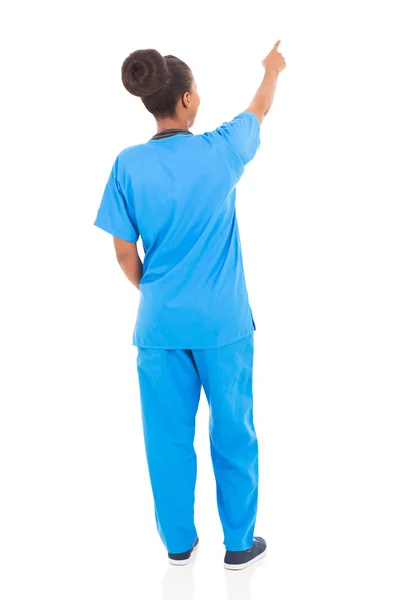 Rear view of african american nurse pointing — Stock Photo, Image