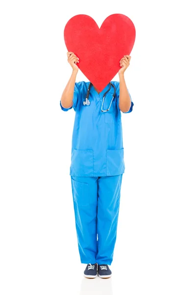 Enfermera africana escondiendo su cara detrás de la forma del corazón — Foto de Stock