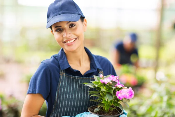 Travailleuse de pépinière tenant un pot de fleurs — Photo