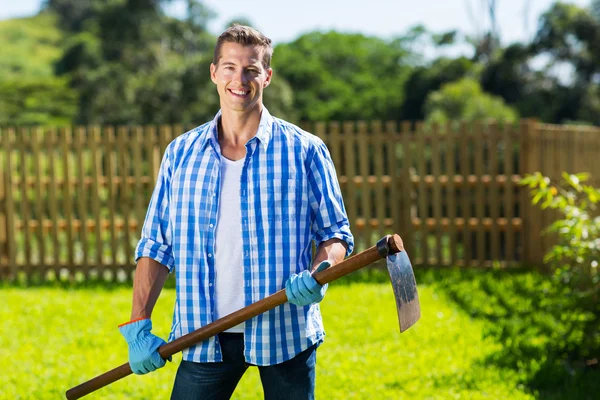 Uomo con una zappa in giardino — Foto Stock