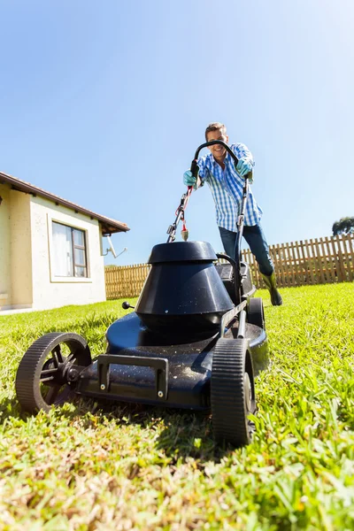 Manliga trädgårdsmästare driva elektriska gräsklippare — Stockfoto
