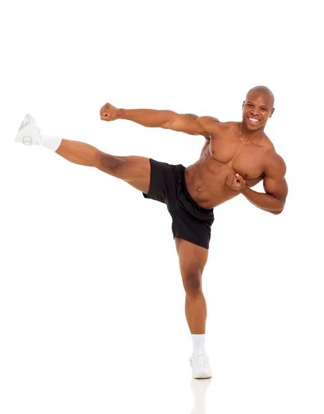 Active african muscular man kicking — Stock Photo, Image