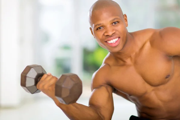 Hombre africano haciendo ejercicio con pesas en casa —  Fotos de Stock