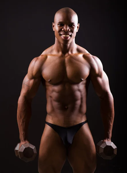 Muskulöser schwarzer Mann mit zwei Kurzhanteln — Stockfoto