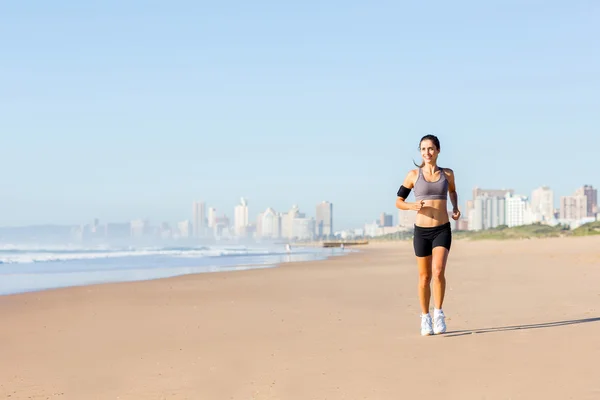 Kvinnan joggar på stranden — Stockfoto